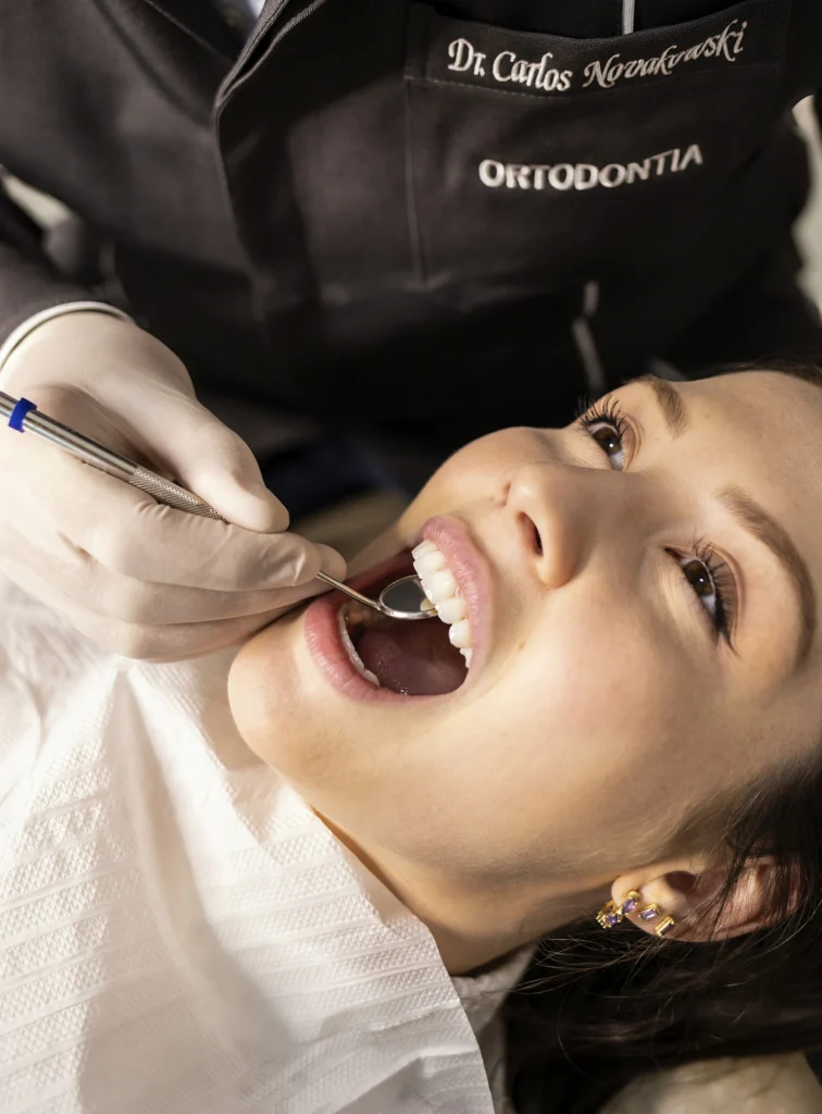 Home 1 Orthodontist examining a patient, the consultation an orthodontic marketing agency helps a practice win